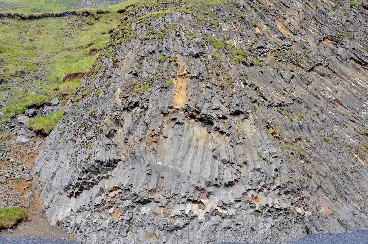 Stuðlaberg: sexstrendar basaltsúlur í klettavegg við Reynisfjöru.